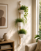 Suporte vertical de parede em bambu com três vasos brancos e plantas, montado numa sala de estar